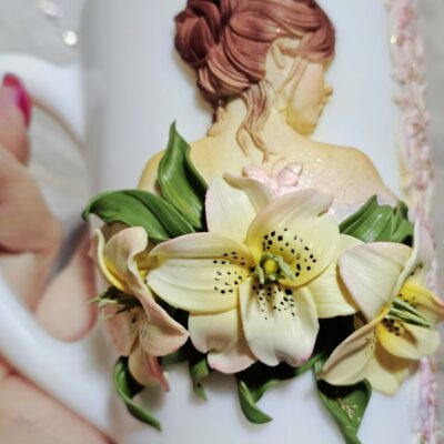 🌸 Чашка с девушкой и лилиями — эксклюзив ручной работы 🌸 Представляем вам по-настоящему волшебную чашку, украшенную лепкой из полимерной глины — на ней изображена изящная девушка, окружённая утончёнными лилиями. Каждая деталь — от изгибов лепестков до нежных черт лица — выполнена вручную с любовью и трепетом. Дополняет композицию изысканная инкрустация стразами, которые придают чашке сияние и особое очарование. 💫 Эксклюзивное изделие в единственном экземпляре 🌺 Авторская лепка: девушка и лилии 💎 Инкрустация стразами 🖐️ Полностью ручная работа