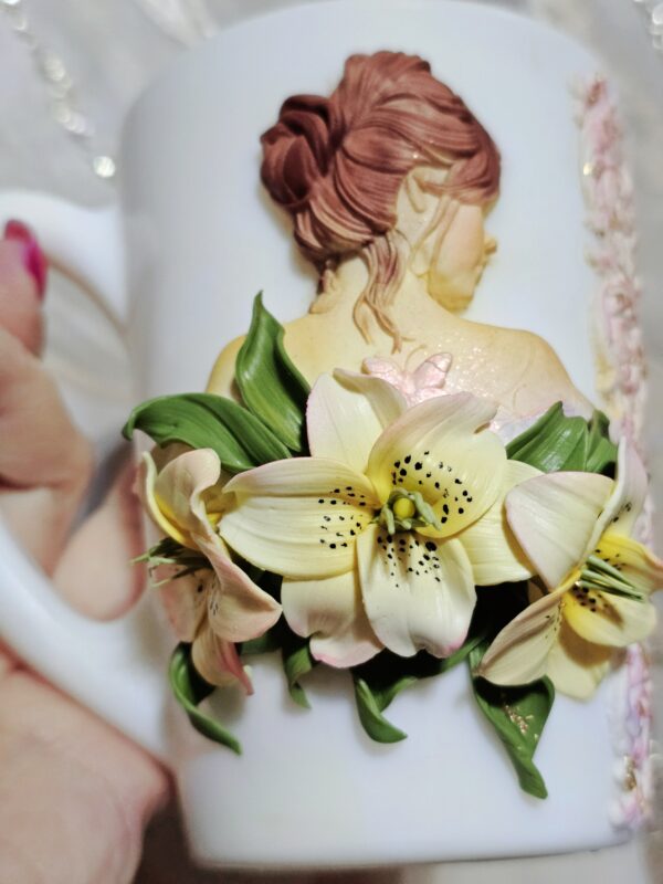 🌸 Чашка с девушкой и лилиями — эксклюзив ручной работы 🌸 Представляем вам по-настоящему волшебную чашку, украшенную лепкой из полимерной глины — на ней изображена изящная девушка, окружённая утончёнными лилиями. Каждая деталь — от изгибов лепестков до нежных черт лица — выполнена вручную с любовью и трепетом. Дополняет композицию изысканная инкрустация стразами, которые придают чашке сияние и особое очарование. 💫 Эксклюзивное изделие в единственном экземпляре 🌺 Авторская лепка: девушка и лилии 💎 Инкрустация стразами 🖐️ Полностью ручная работа